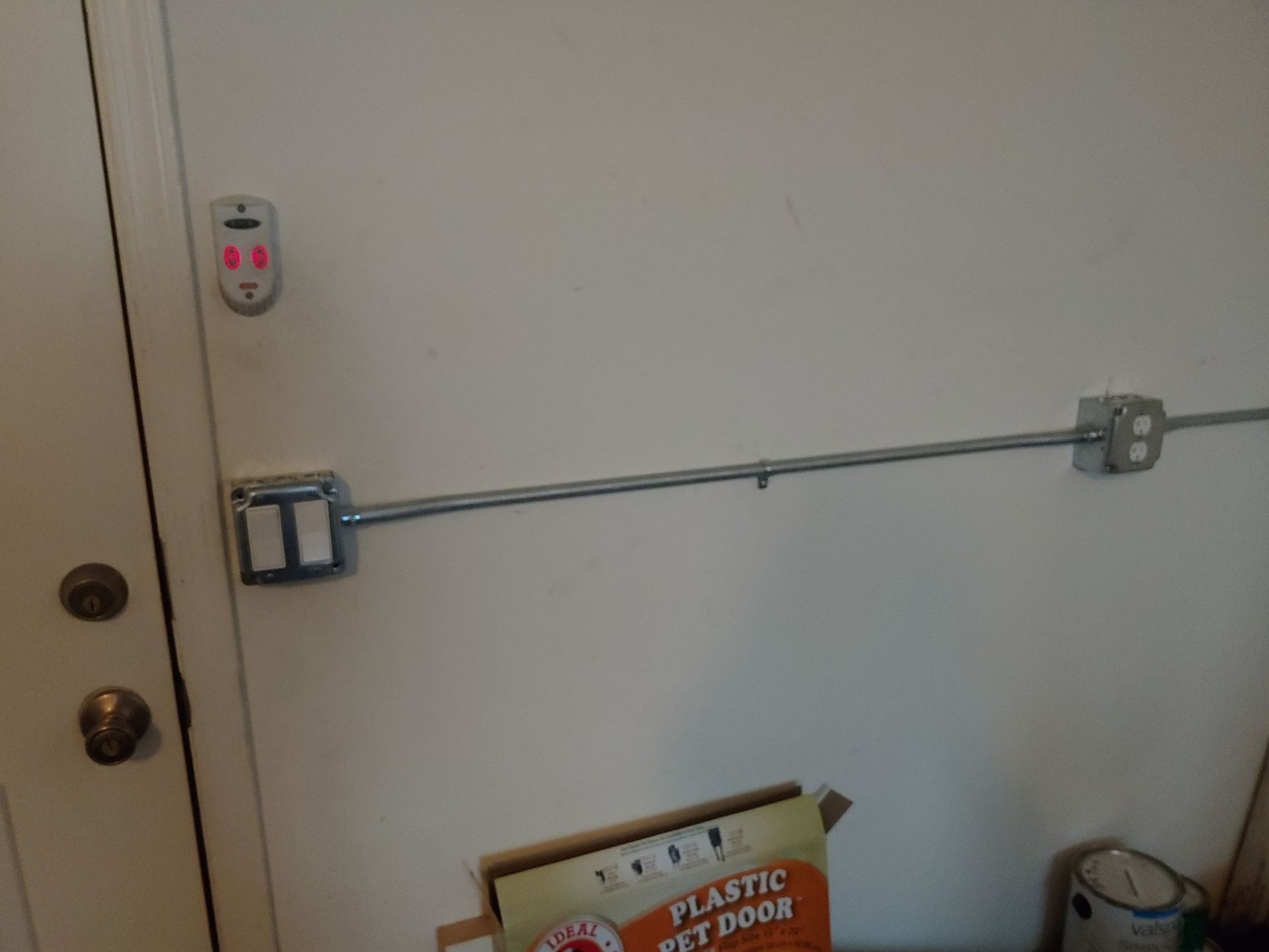 A plastic pet door is sitting on a table next to a door.