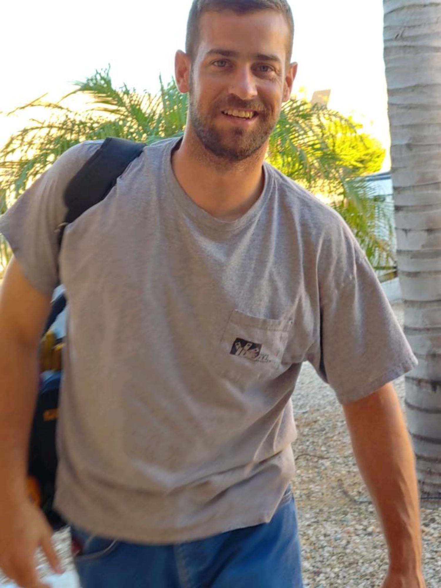 A man wearing a grey t-shirt with a pocket on the front