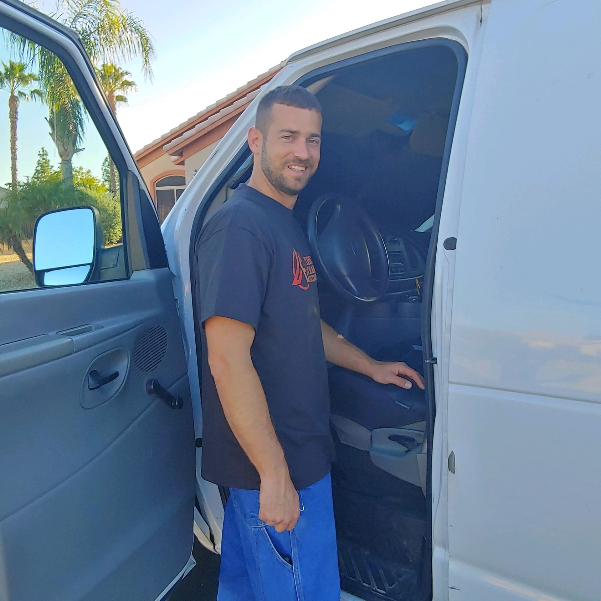 A man in a black shirt is getting out of a van