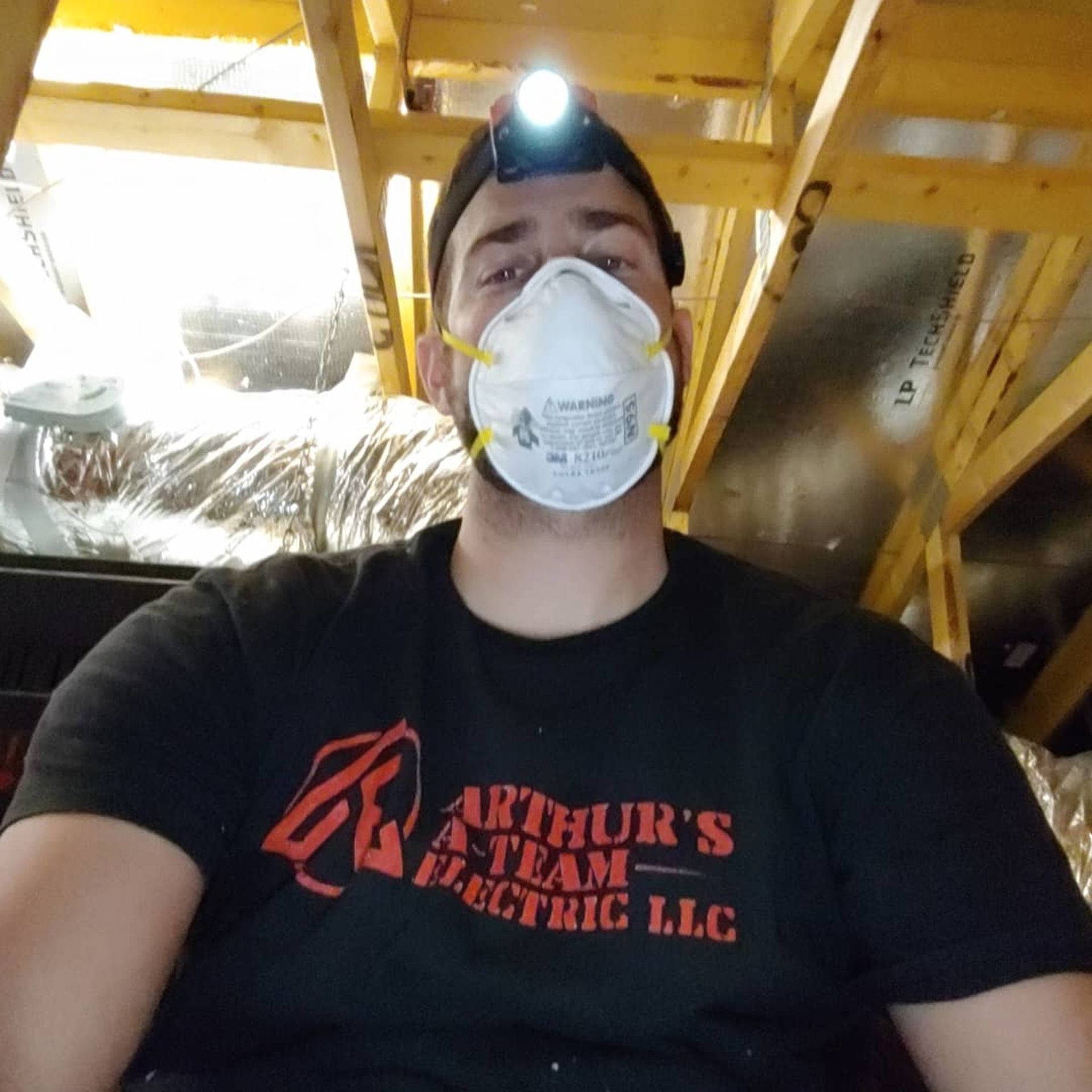 A man wearing a black shirt that says arthur 's a team electric llc