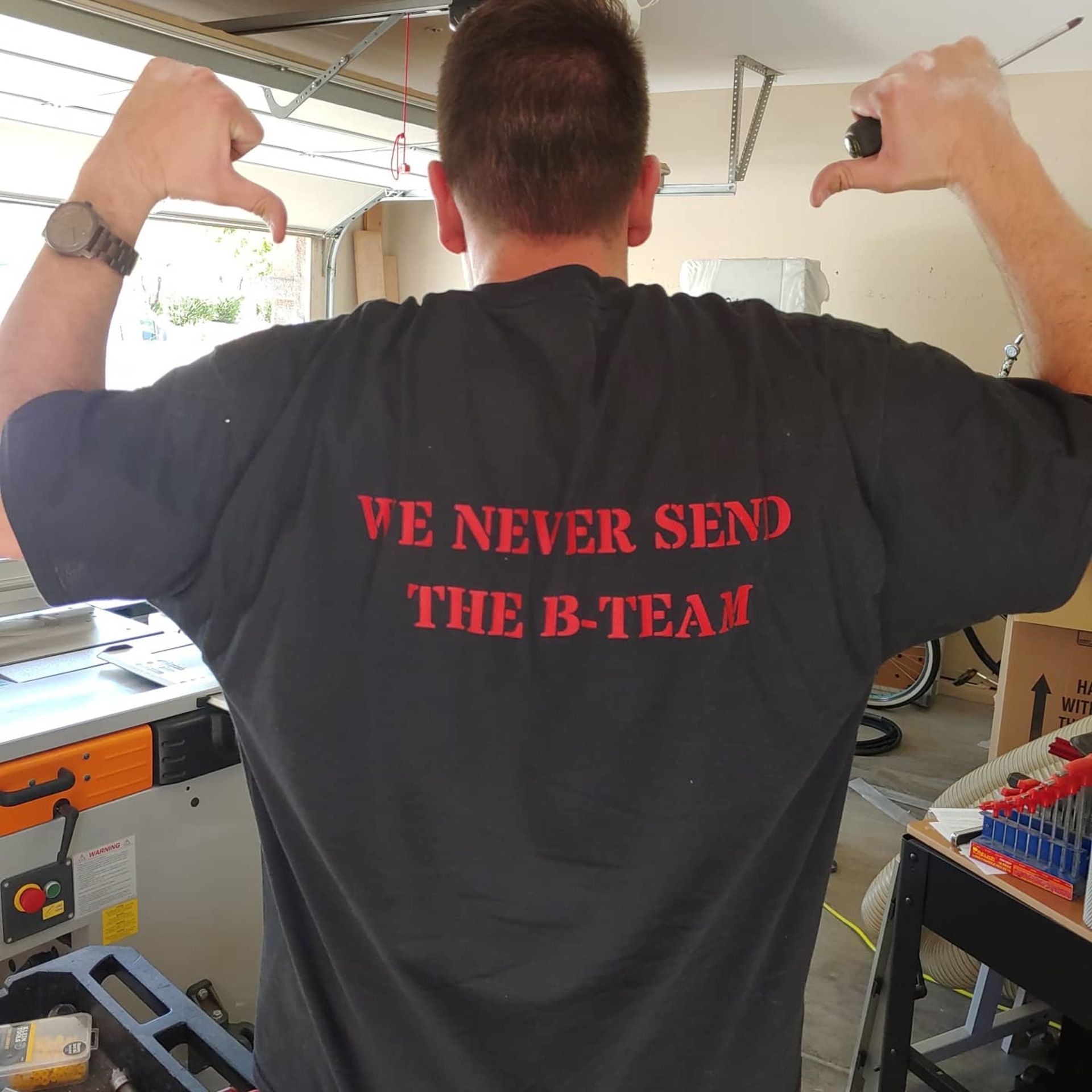 A man wearing a black shirt that says we never send the b-team