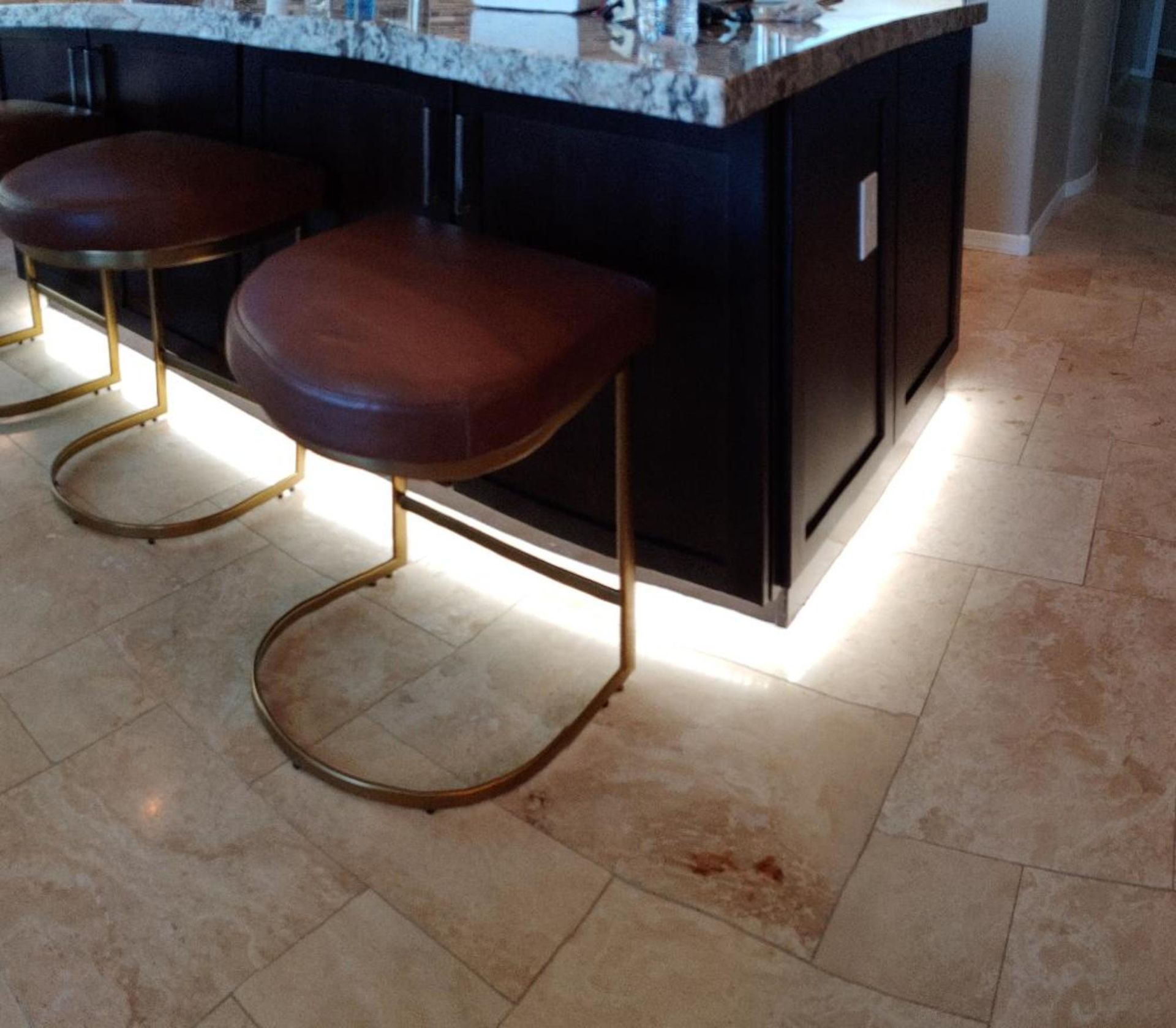 A kitchen island with stools underneath it