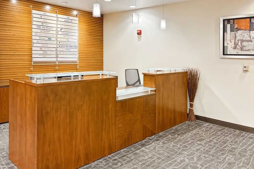 A hallway in a building with a lot of glass doors and a rug on the floor.