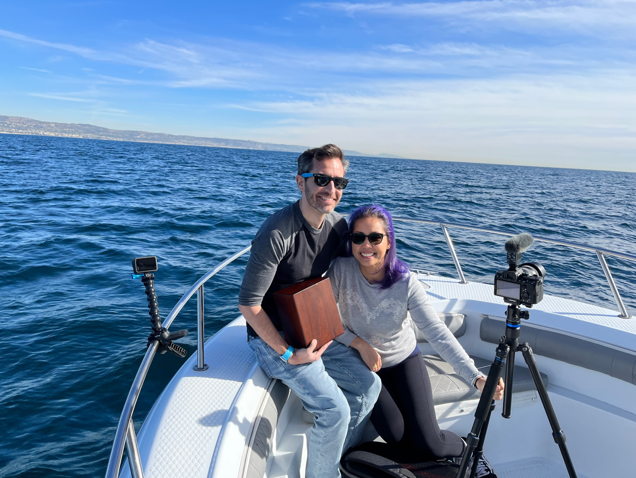 A man and a woman are sitting on a boat in the ocean.