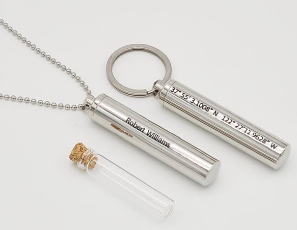 A necklace with a keychain and a vial with the name robert written on it