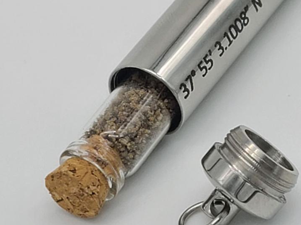 A bottle with a cork and the coordinates 37 55 3 1008 n