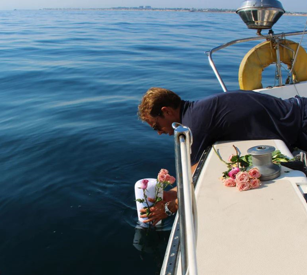 A man on a boat holding a bucket of flowers