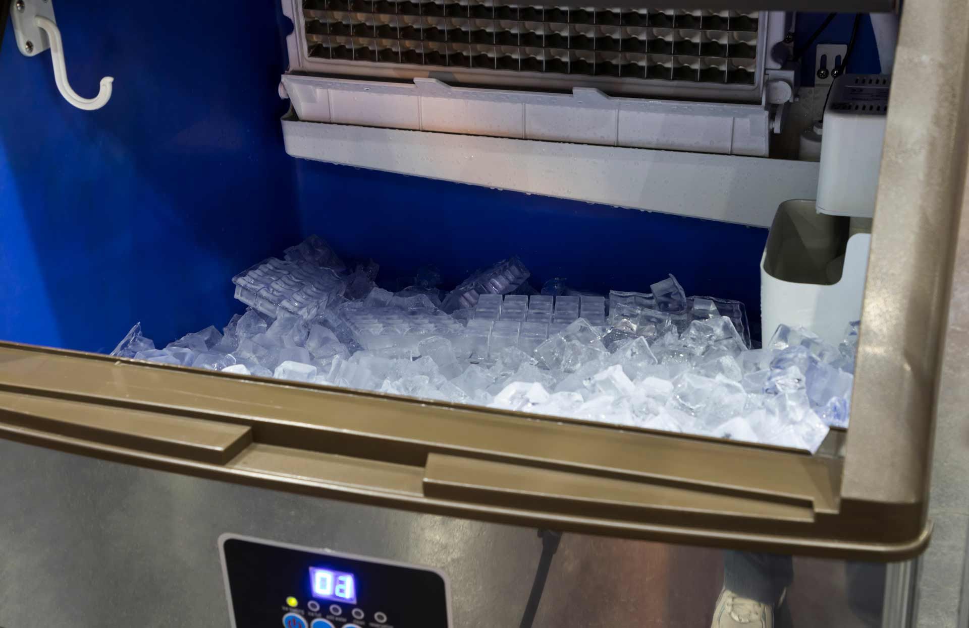Ice machine with a full bin of cubed ice, open for access.