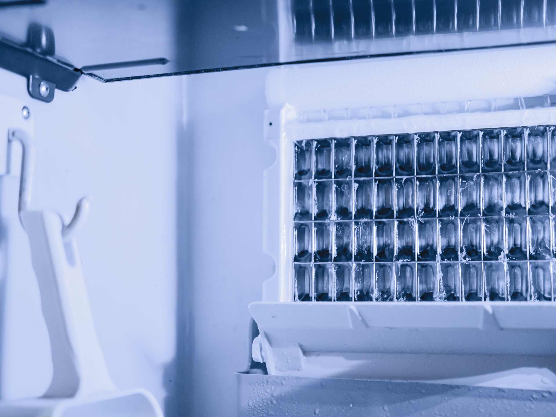 Ice maker with a grid of ice cubes, viewed from inside. White and blue tones.