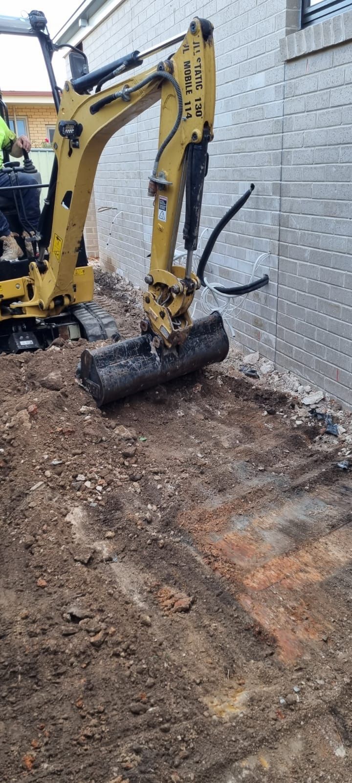 A bulldozer is moving a pile of gravel on a construction site.