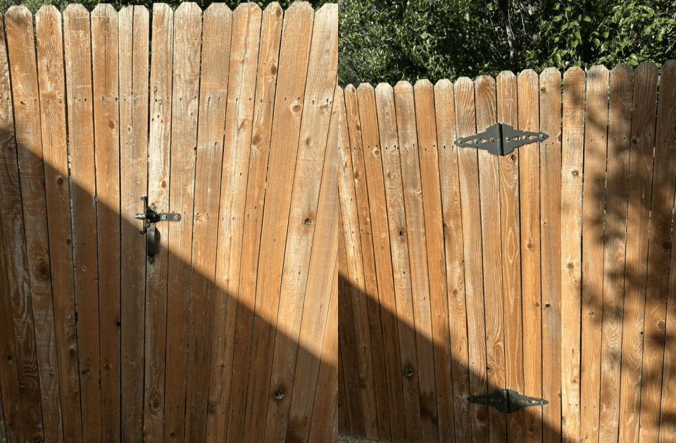 Wooden gate with decorative black hardware, casting shadows in sunlight.