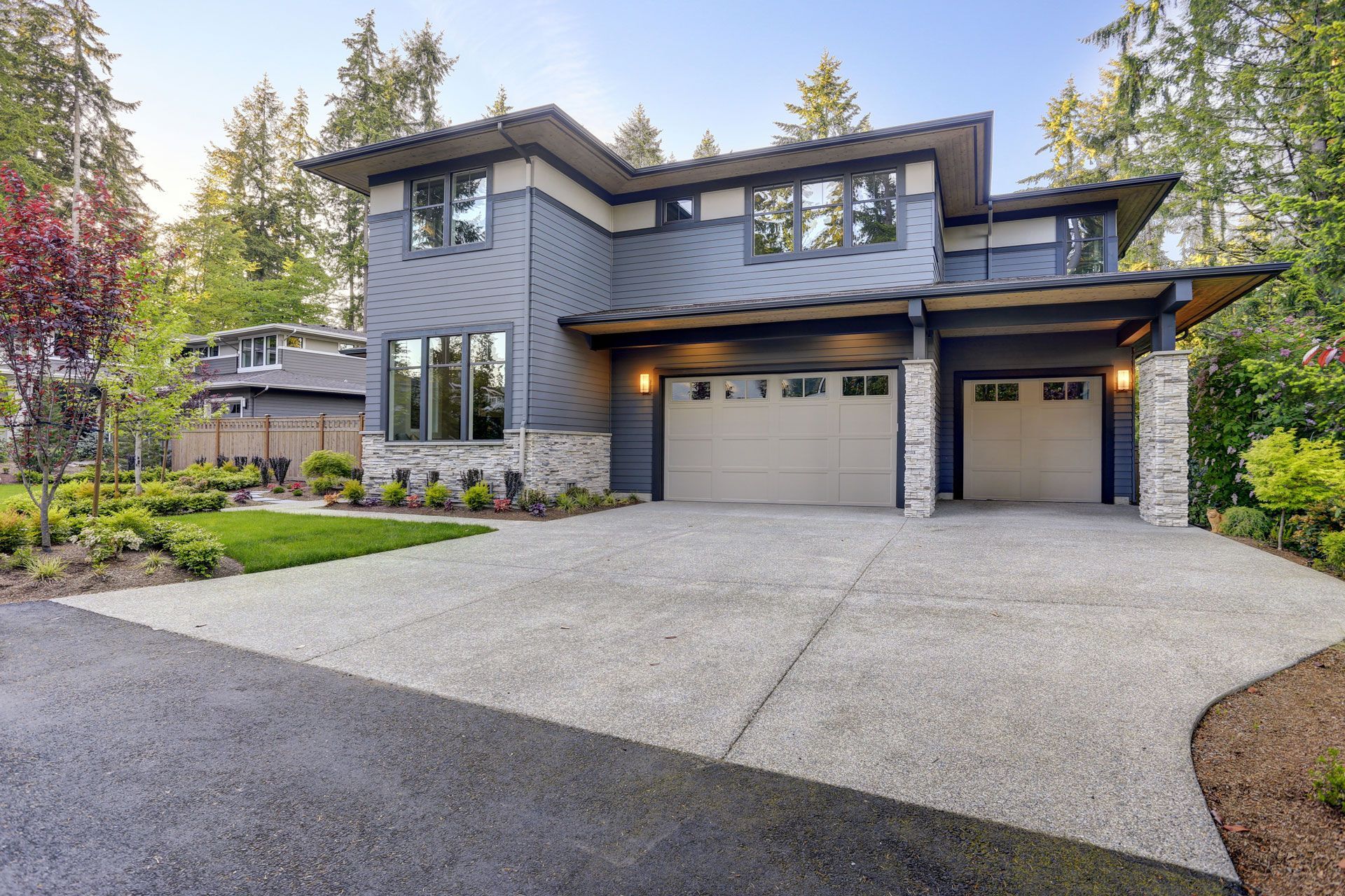 A large house with two garage doors and a driveway.
