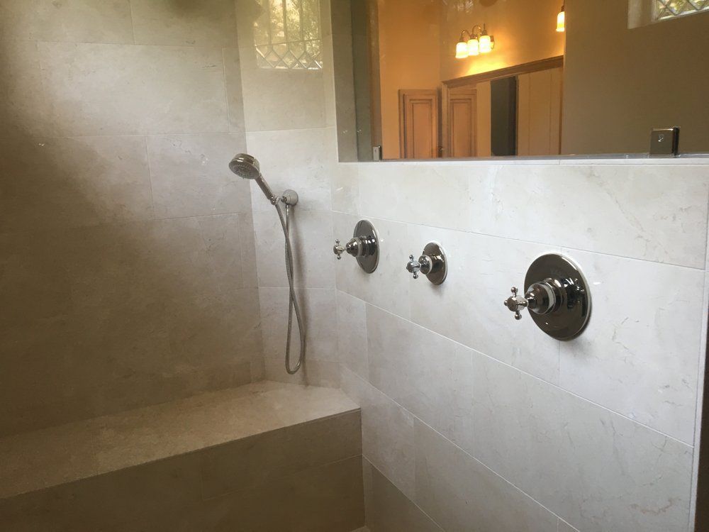 A bathroom with a walk in shower and a window.