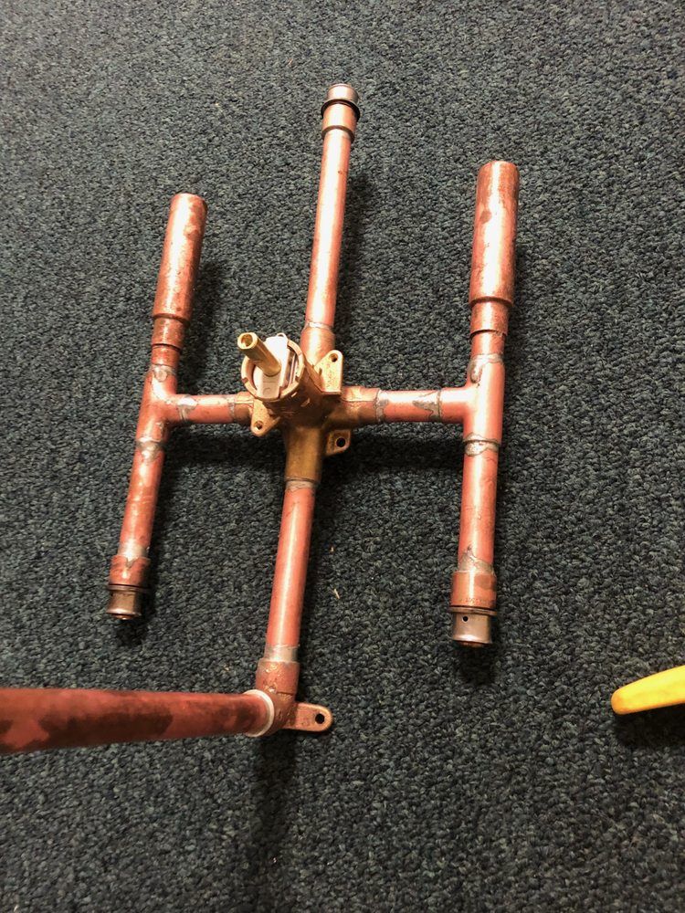 A kitchen with a stove and a shelf with pots and pans on it.