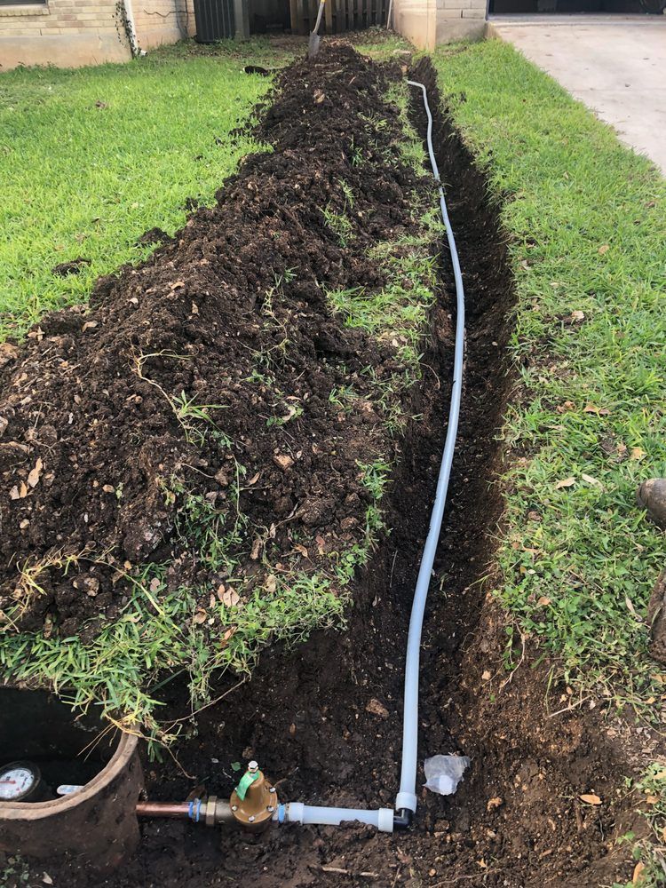 A hose is being installed in the dirt next to a water meter.