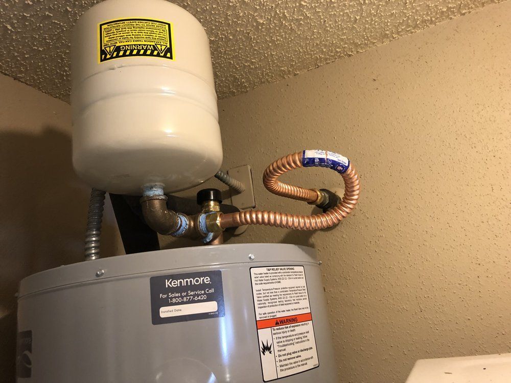 A water heater with a tank attached to it in a room.