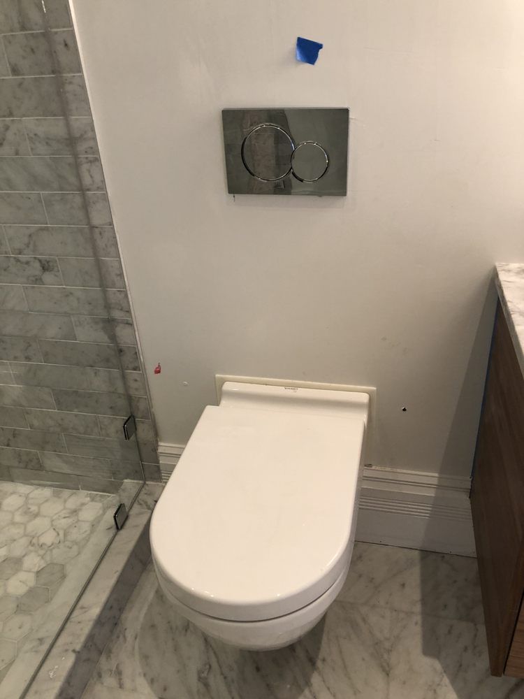 A white toilet is sitting in a bathroom next to a shower.