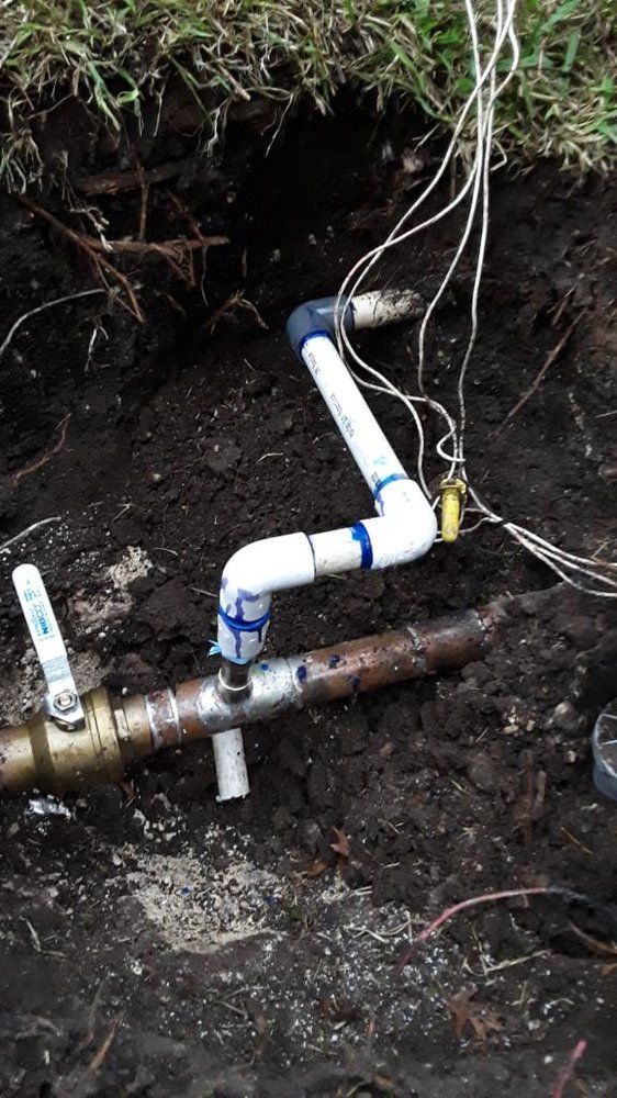 A close up of a water pipe in the dirt.