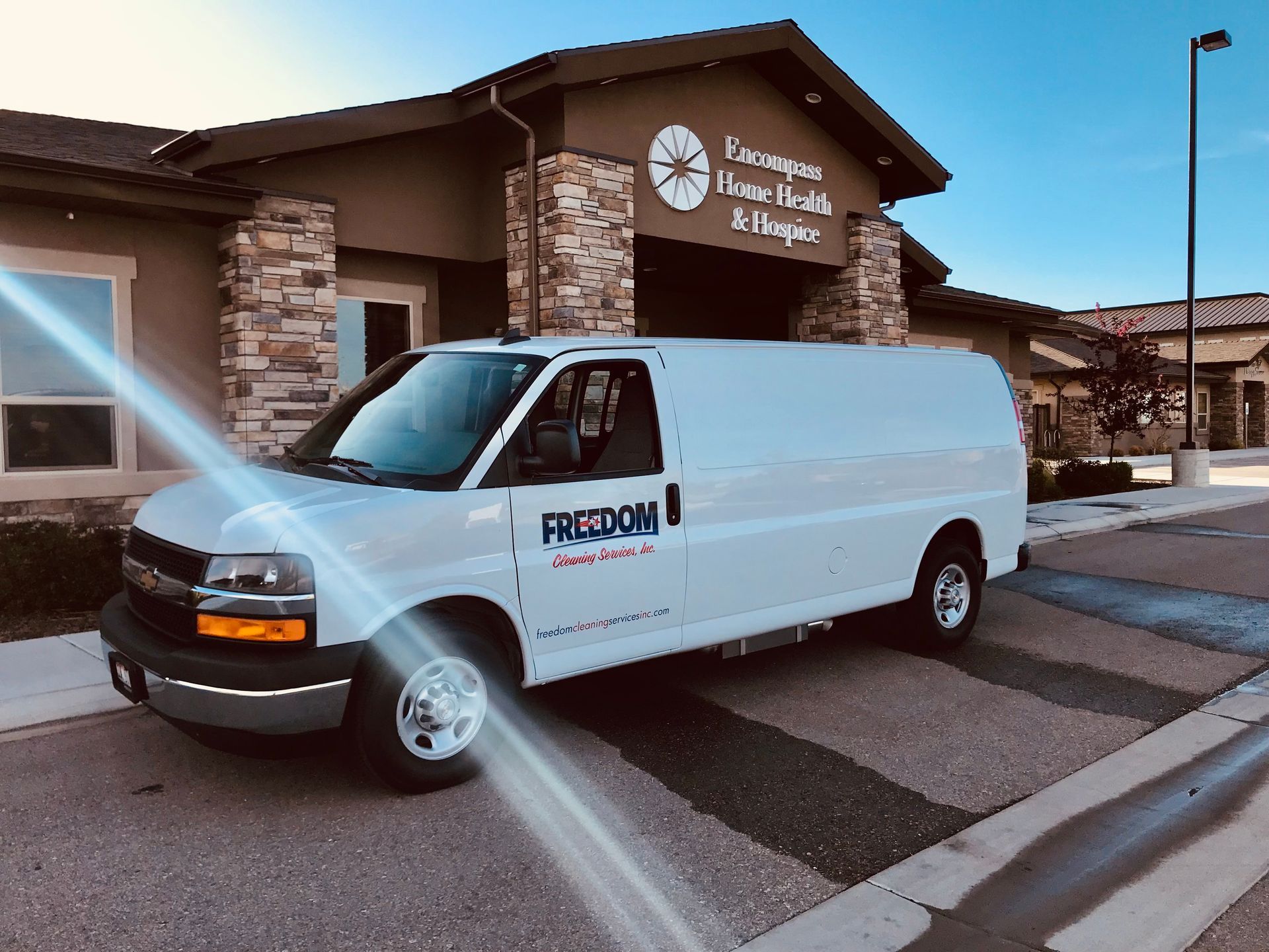 A white van with the word freedom on the side is parked in front of a building.