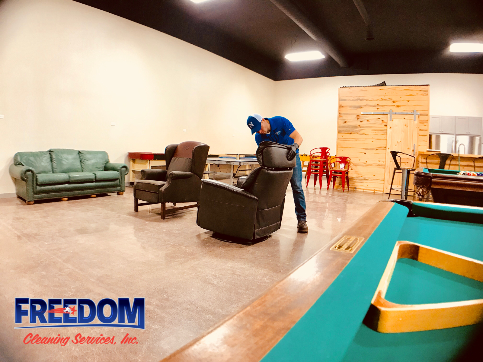 A man is standing next to a pool table in a living room.