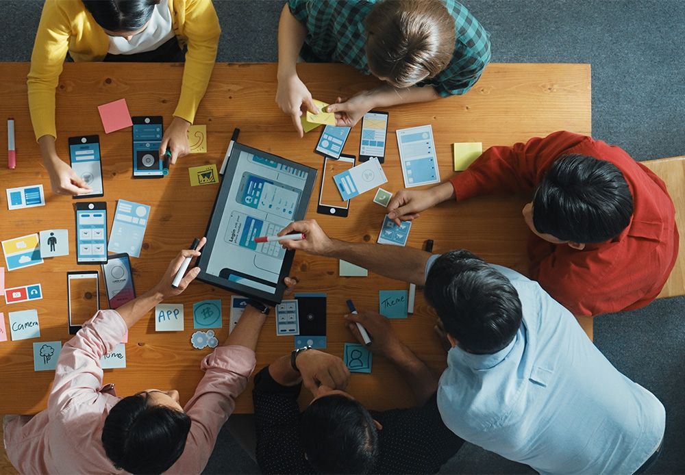 A group of people are sitting around a table working on a project.