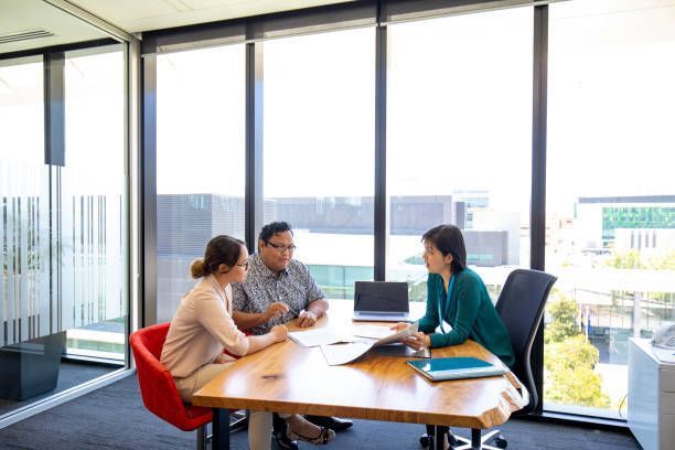 A group of people are sitting around a table in a conference room.