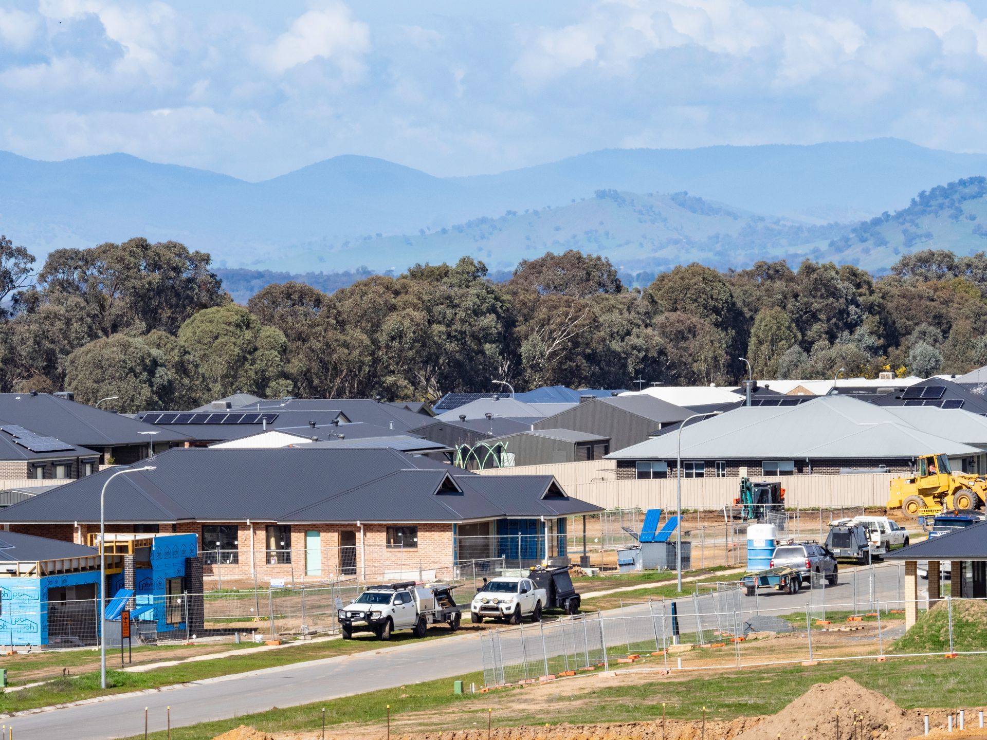 A city street lined with tall buildings on a sunny day.
