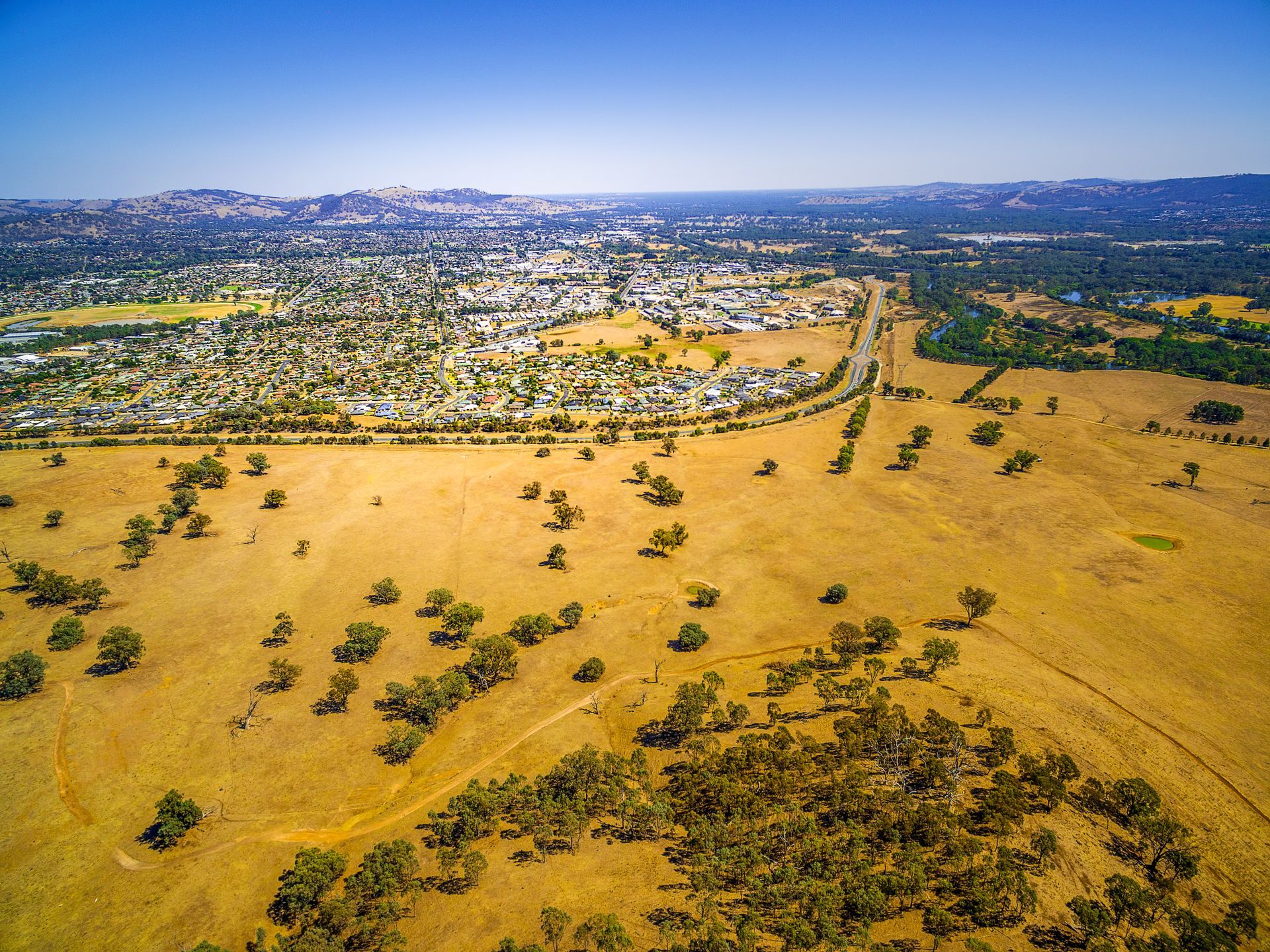 An aerial view of a construction site with mountains in the background.