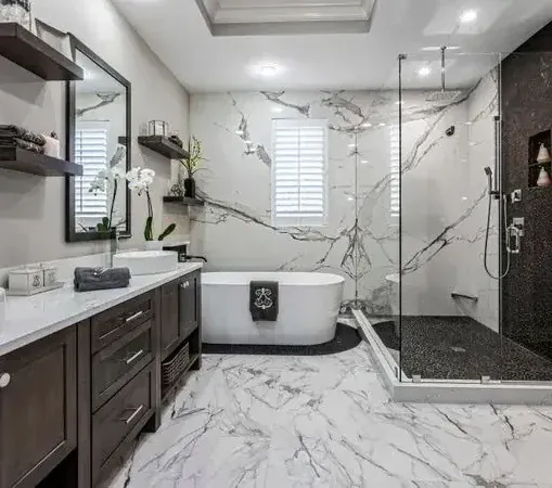Luxurious bathroom with marble walls and floors, dark wood vanity, and a glass shower.