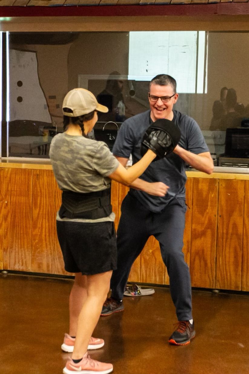 Adults practicing partner self-defense drills at Agoge Krav Maga in Lindale, TX.