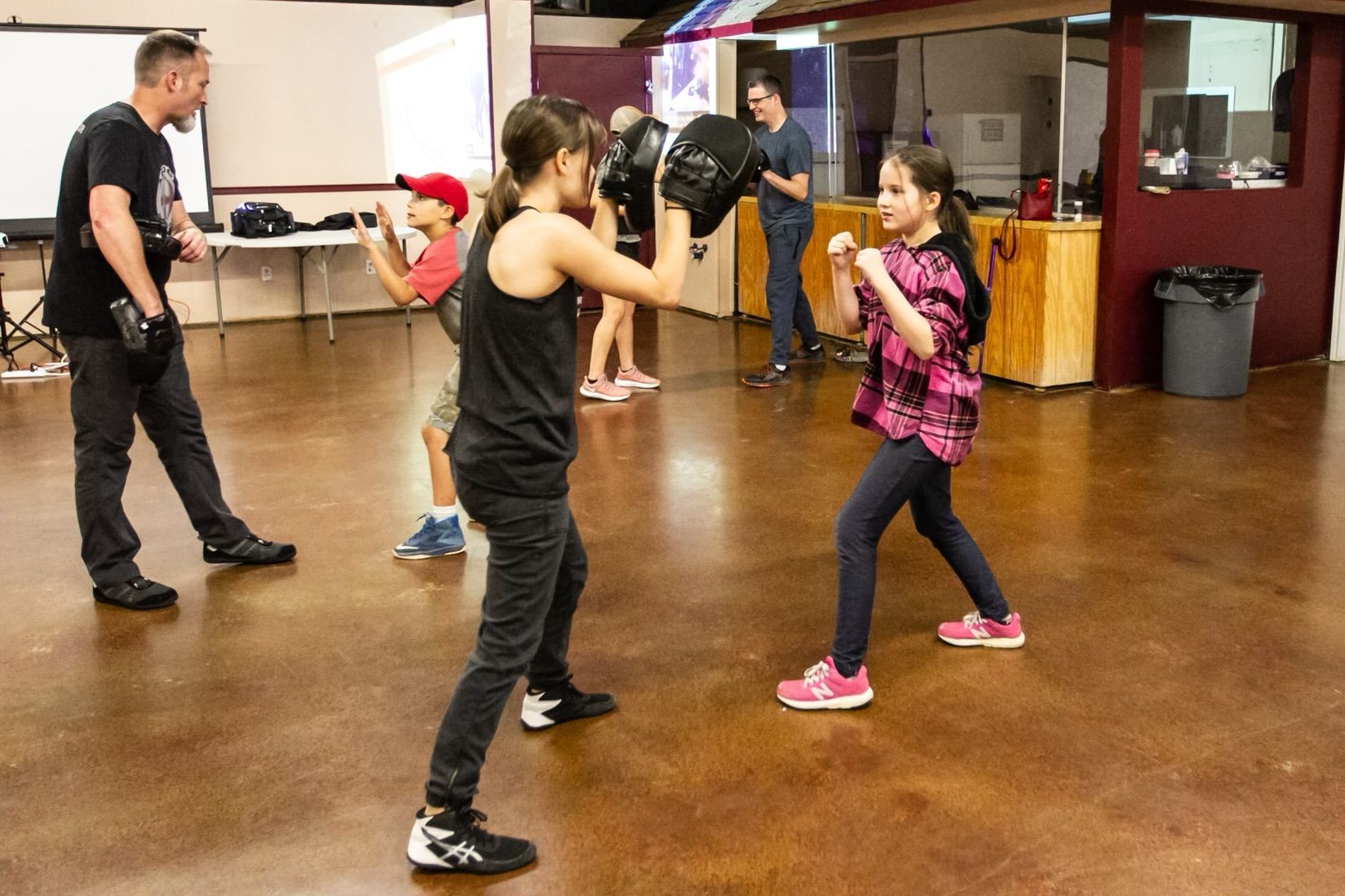 Students practice partner self-defense drills at Agoge Krav Maga in Lindale, TX for stress relief and confidence.