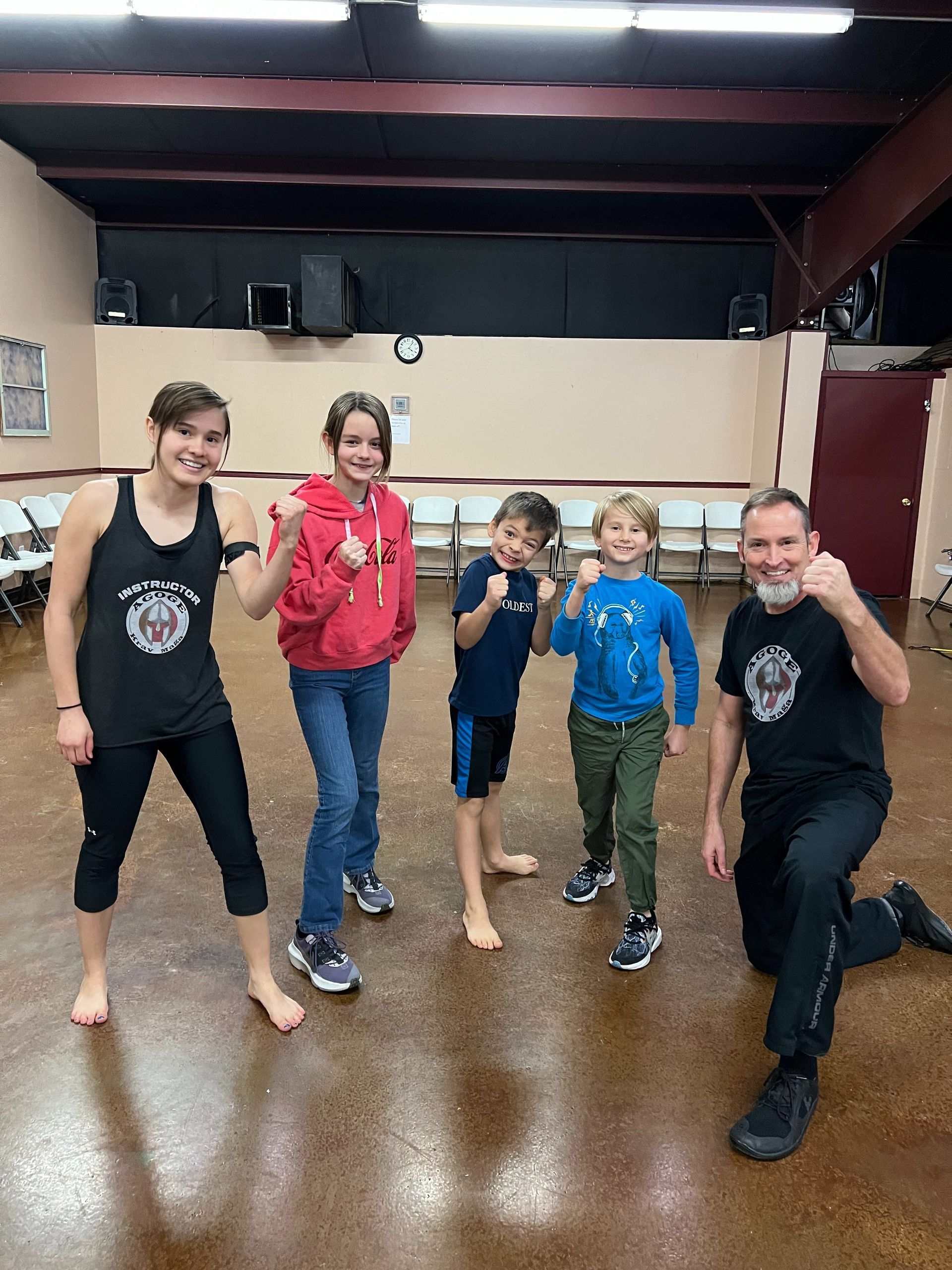 Kids and instructors in a beginner Krav Maga class at Agoge Krav Maga Lindale TX demonstrating defen