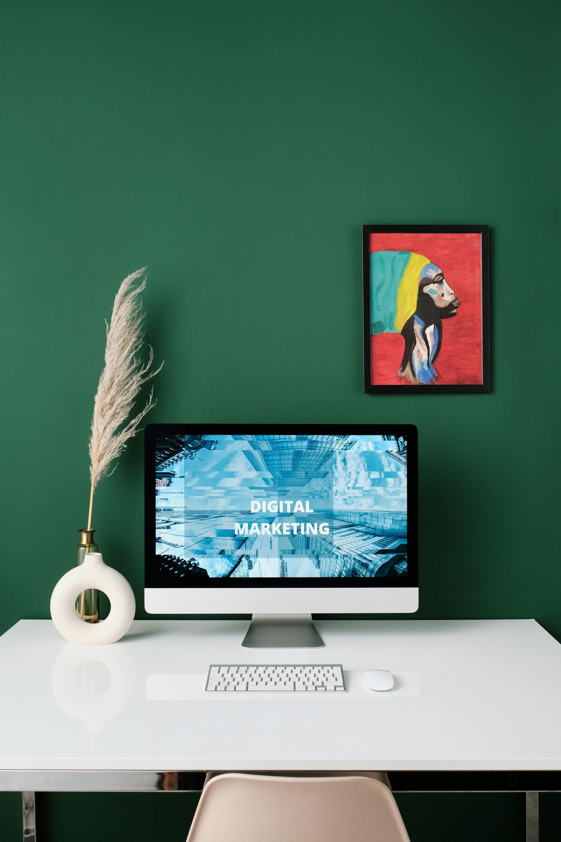 A computer is sitting on a white desk in front of a green wall.