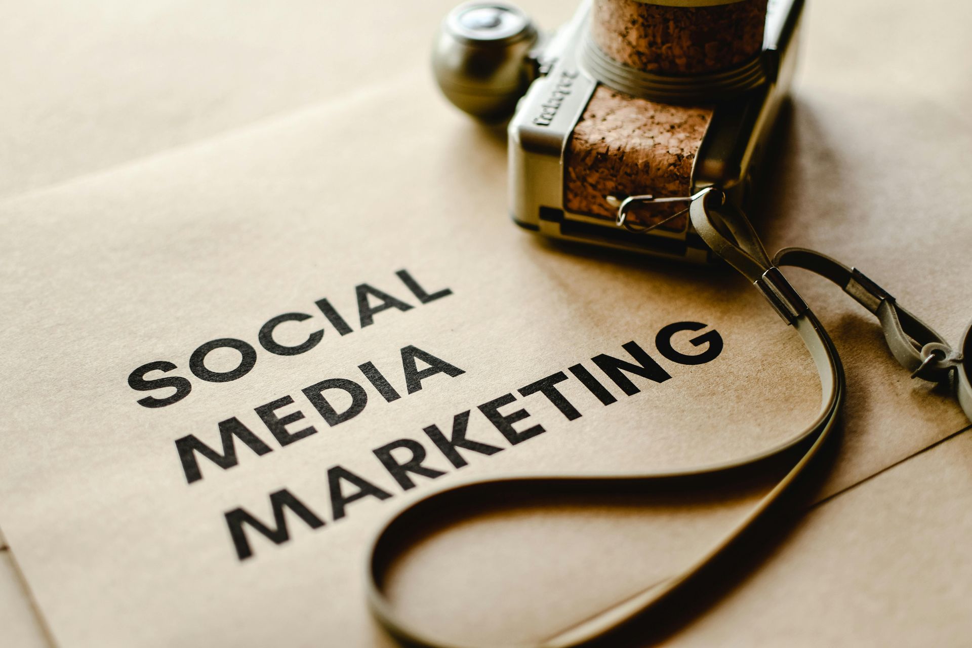 A camera is sitting on top of a piece of paper that says social media marketing.