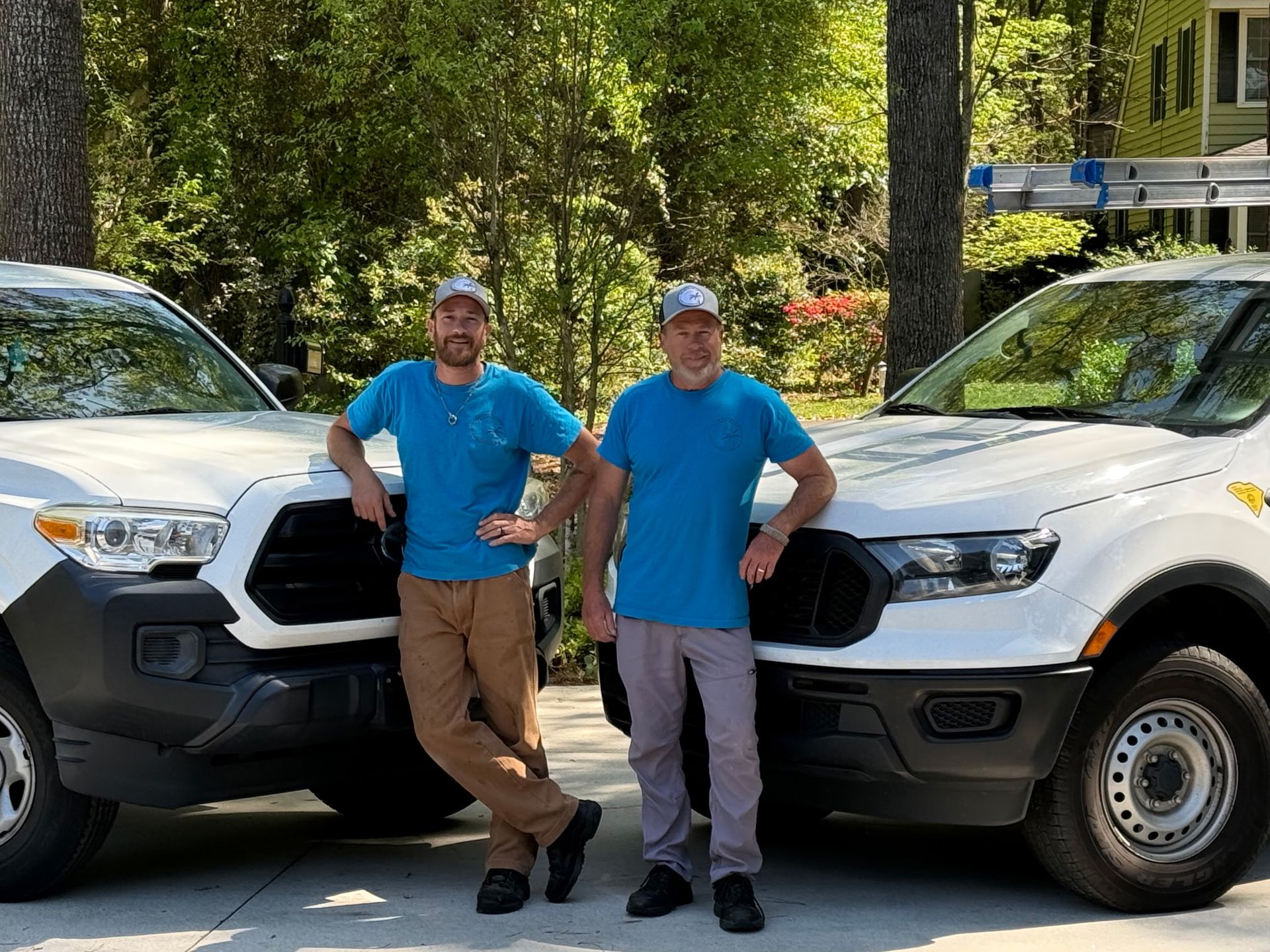 A white truck is parked in front of a yellow house.