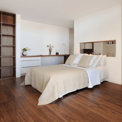 A bedroom with a dark hardwood floor