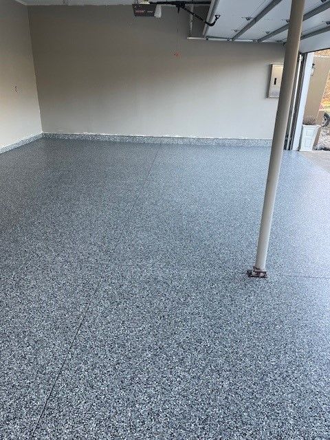 A garage with a gray floor and a white wall.