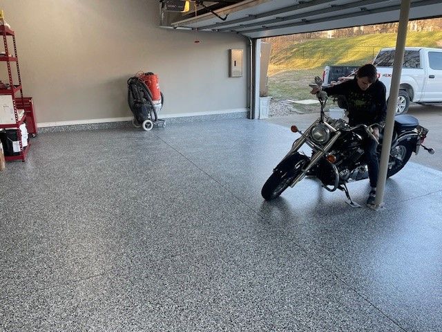 A man is riding a motorcycle in a garage.