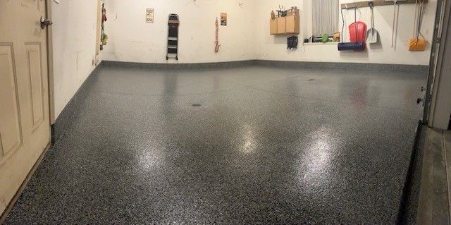 A garage with a gray floor and white walls.