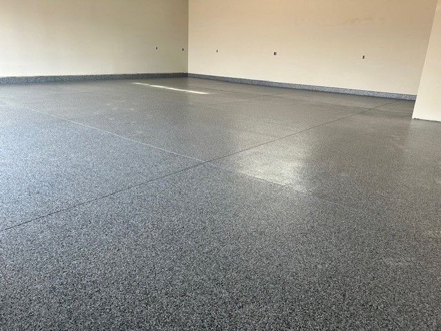 A garage with a gray floor and white walls.