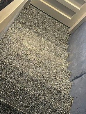 A close up of a staircase with a gray carpet on the floor.
