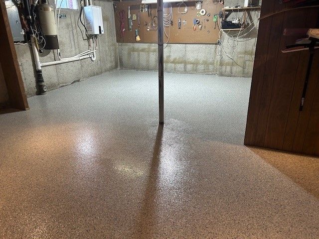 A basement with a concrete floor and a wooden door.