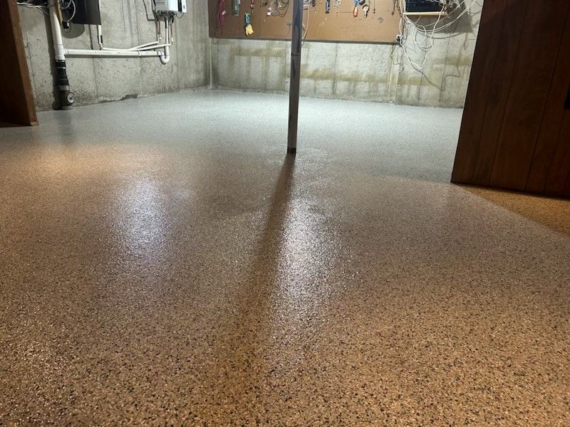 A basement with a concrete wall and a concrete floor.