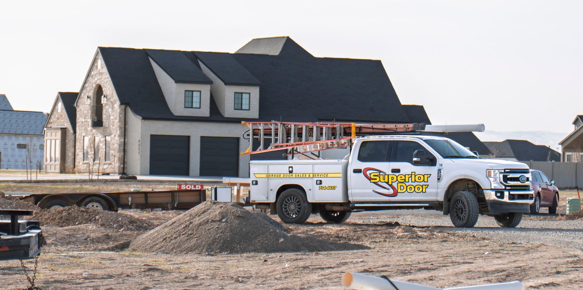 Two construction workers are working on a garage door.