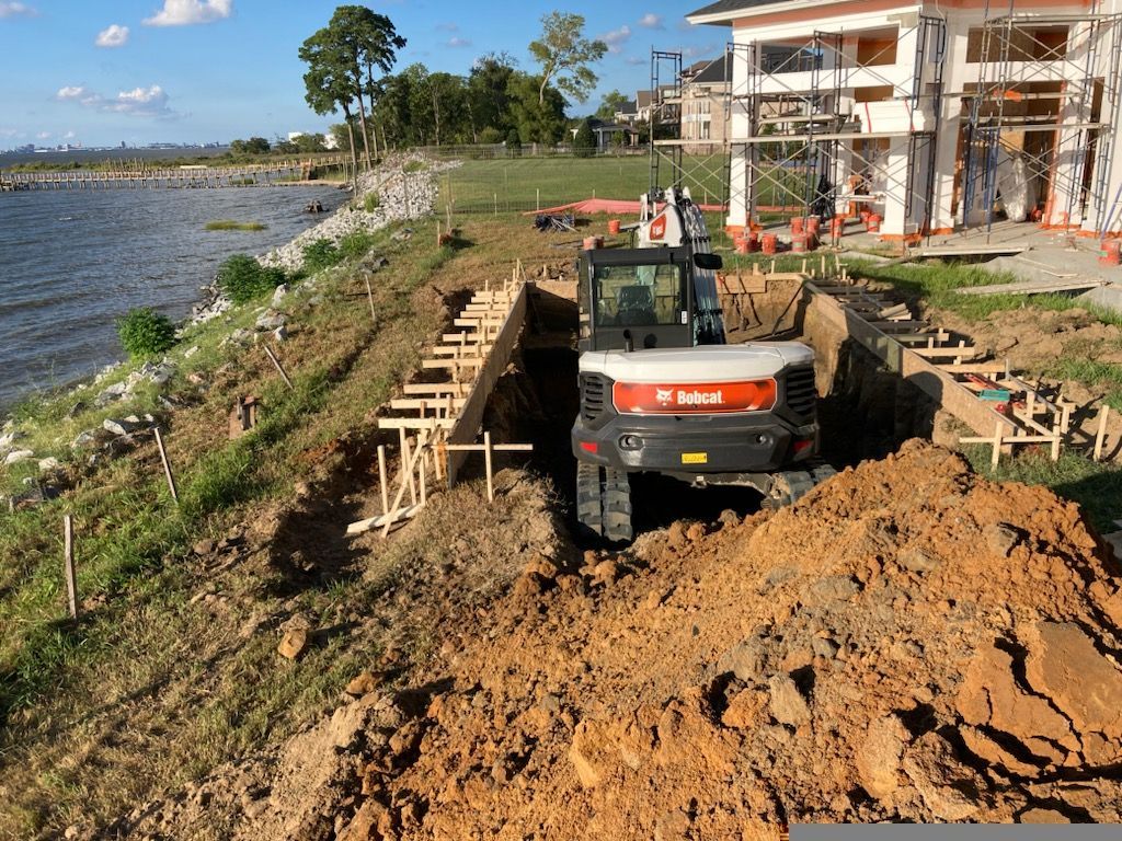 a bulldozer is digging a hole in the ground near a body of water .| Virginia Beach, VA | Atlantis Pools