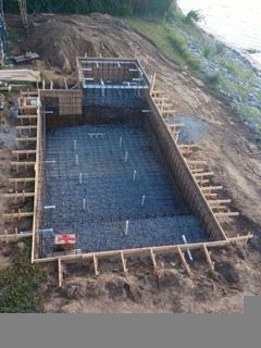 a large swimming pool is being built on the shore of a lake .| Virginia Beach, VA | Atlantis Pools