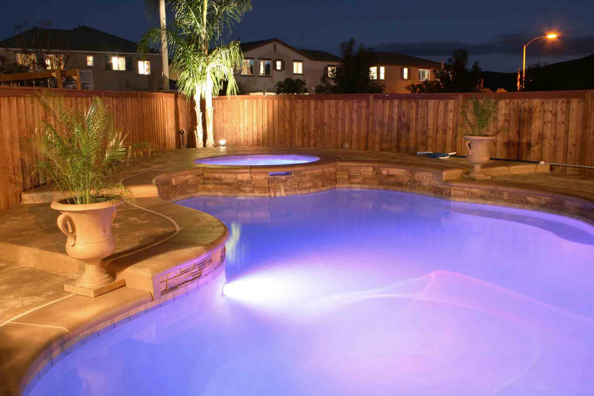 Pool With Fence And Pool With Lavendar Accent Light At Night — Pools in Virginia Beach, VA