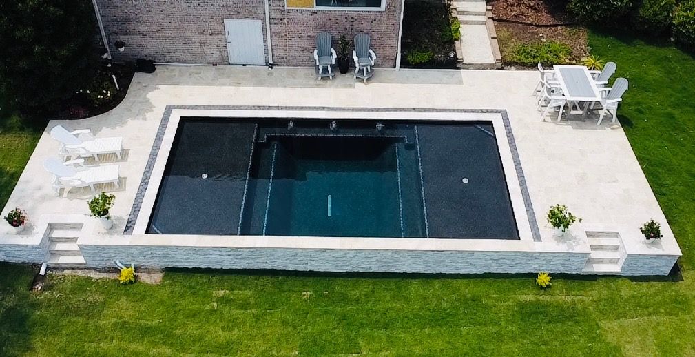 An aerial view of a large swimming pool in the backyard of a house.