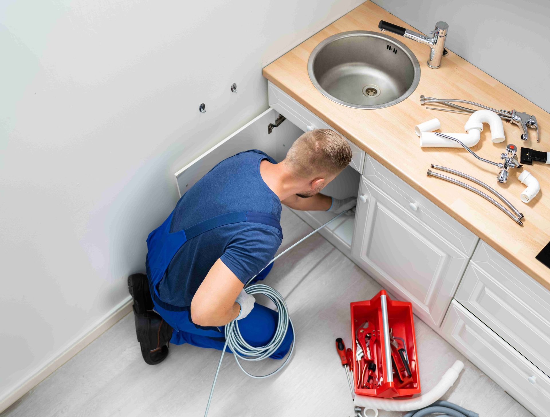a plumber is working under a sink in a kitchen