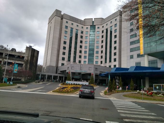a car is driving down a street in front of a large building .